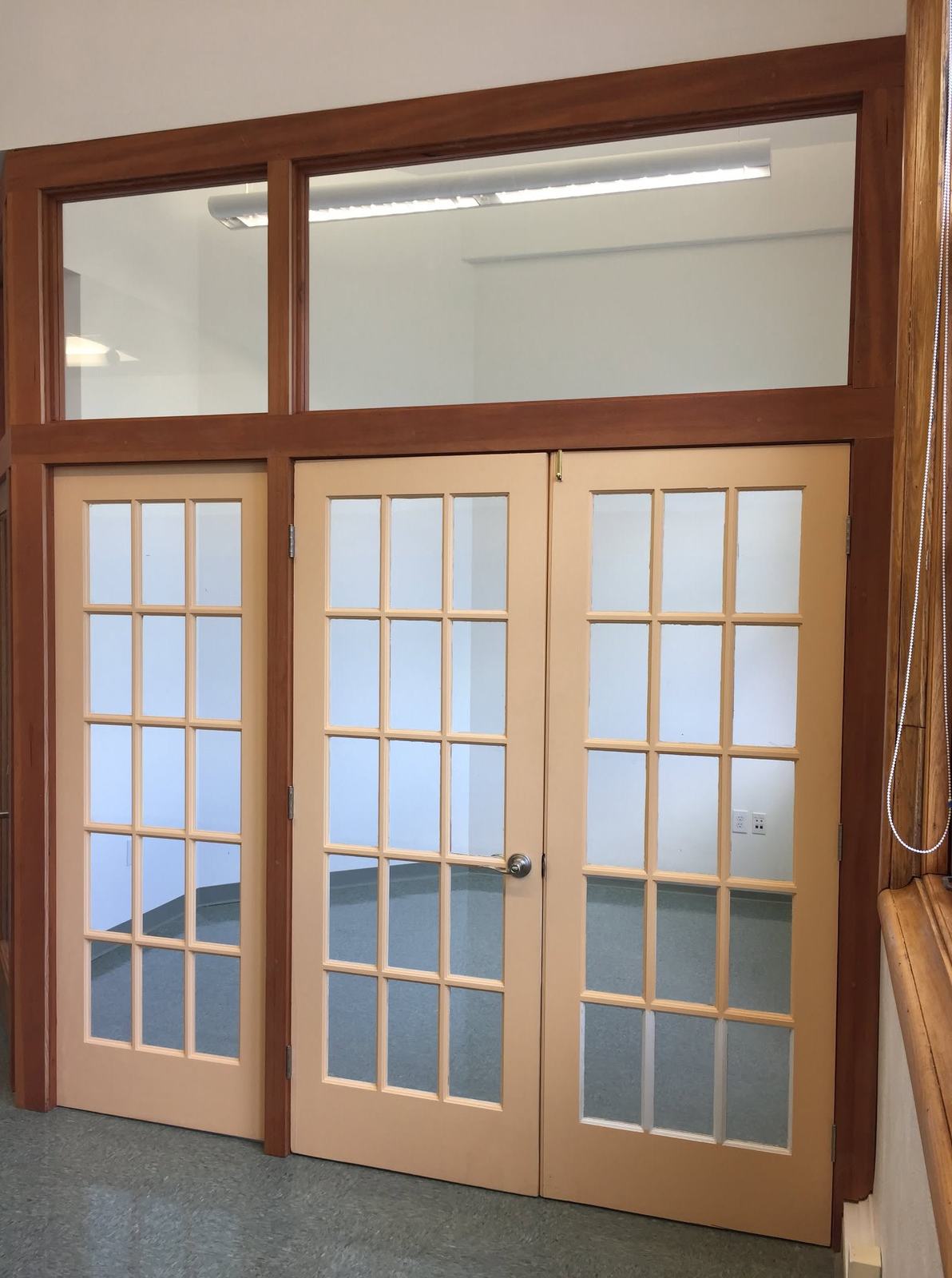 Wood-framed French doors with transom windows