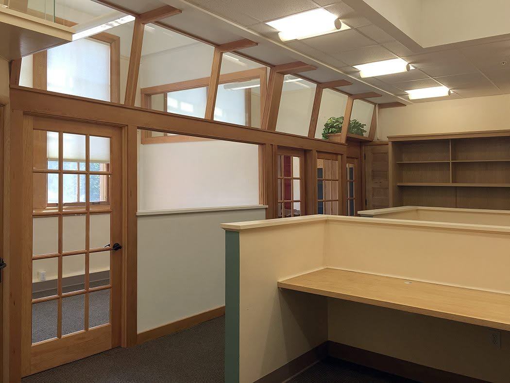 Office with wood-framed glass partition walls and a built-in desk